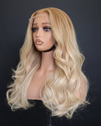 Blonde wig on a mannequin head against a black background