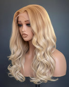 Blonde wig on a mannequin head against a black background