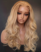 Blonde wig on a mannequin head against a dark background