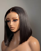 Mannequin head with a black wig on a gray background