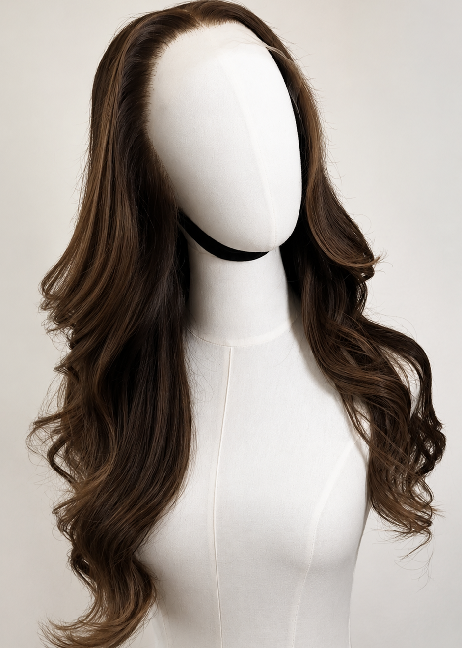 Long, wavy brown wig with deep side parting displayed on a white mannequin head against a light gray background.