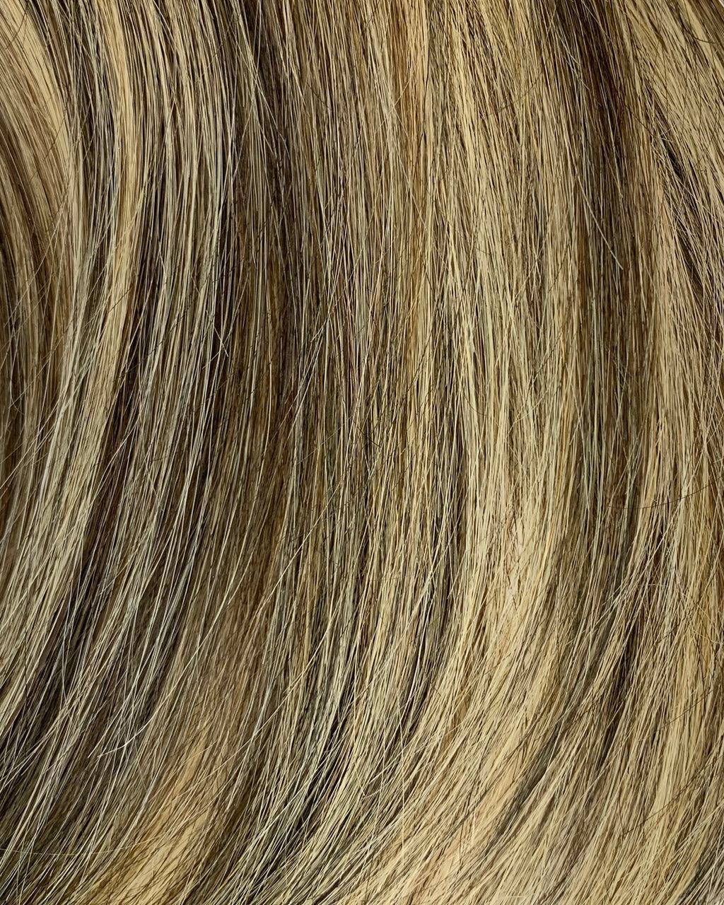 Close-up of brown and blonde hair extensions on a white background