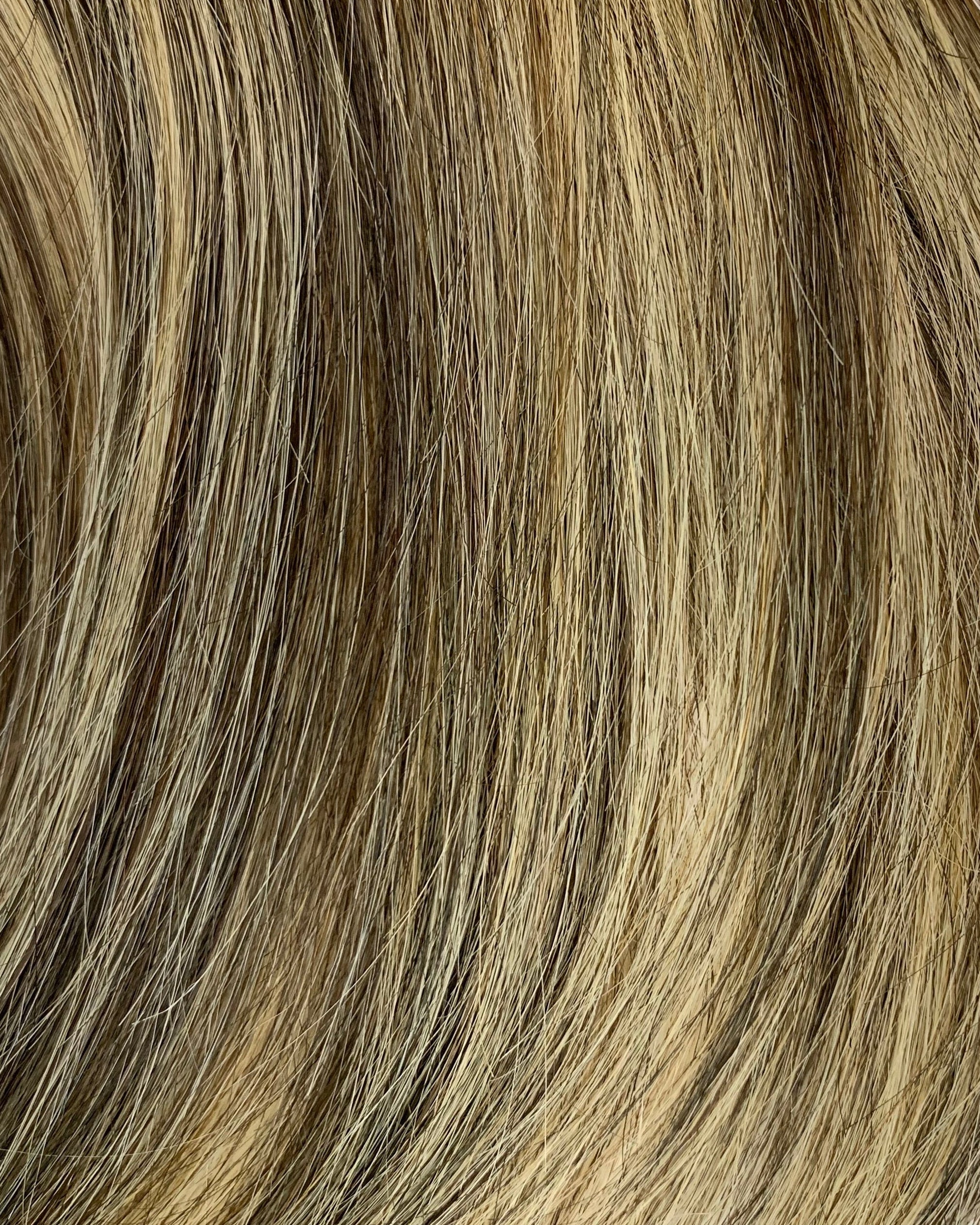 Close-up of brown and blonde hair extensions on a white background