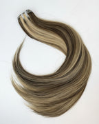 Blonde and brown hair extensions on a white background