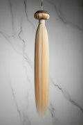 Blonde 613 Vietnamese raw hair extensions wefted bundle on a white background