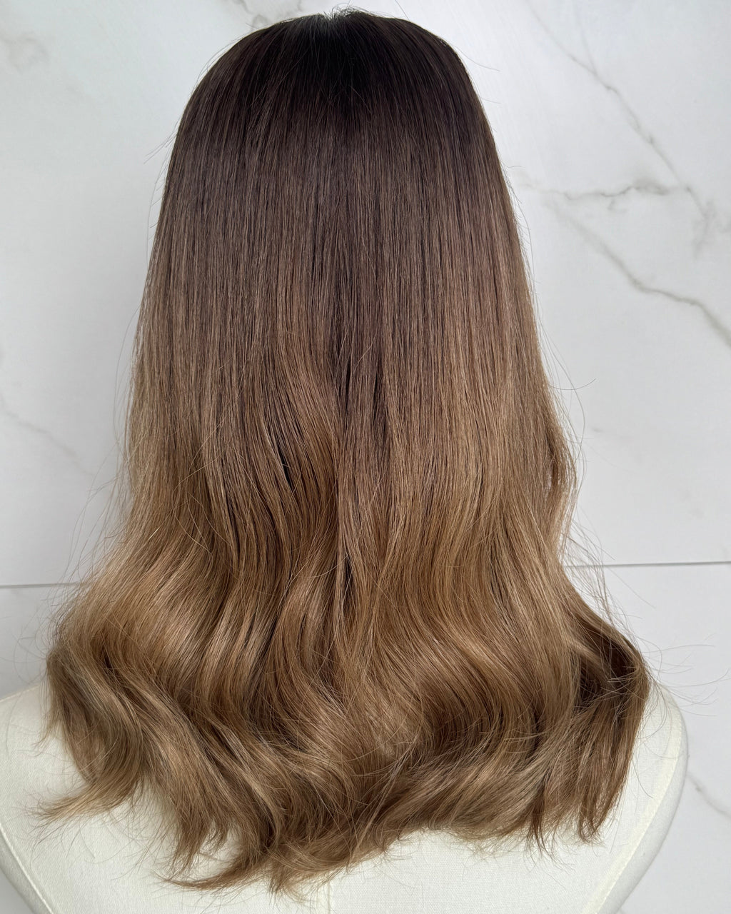 Brown hair extensions on a white surface