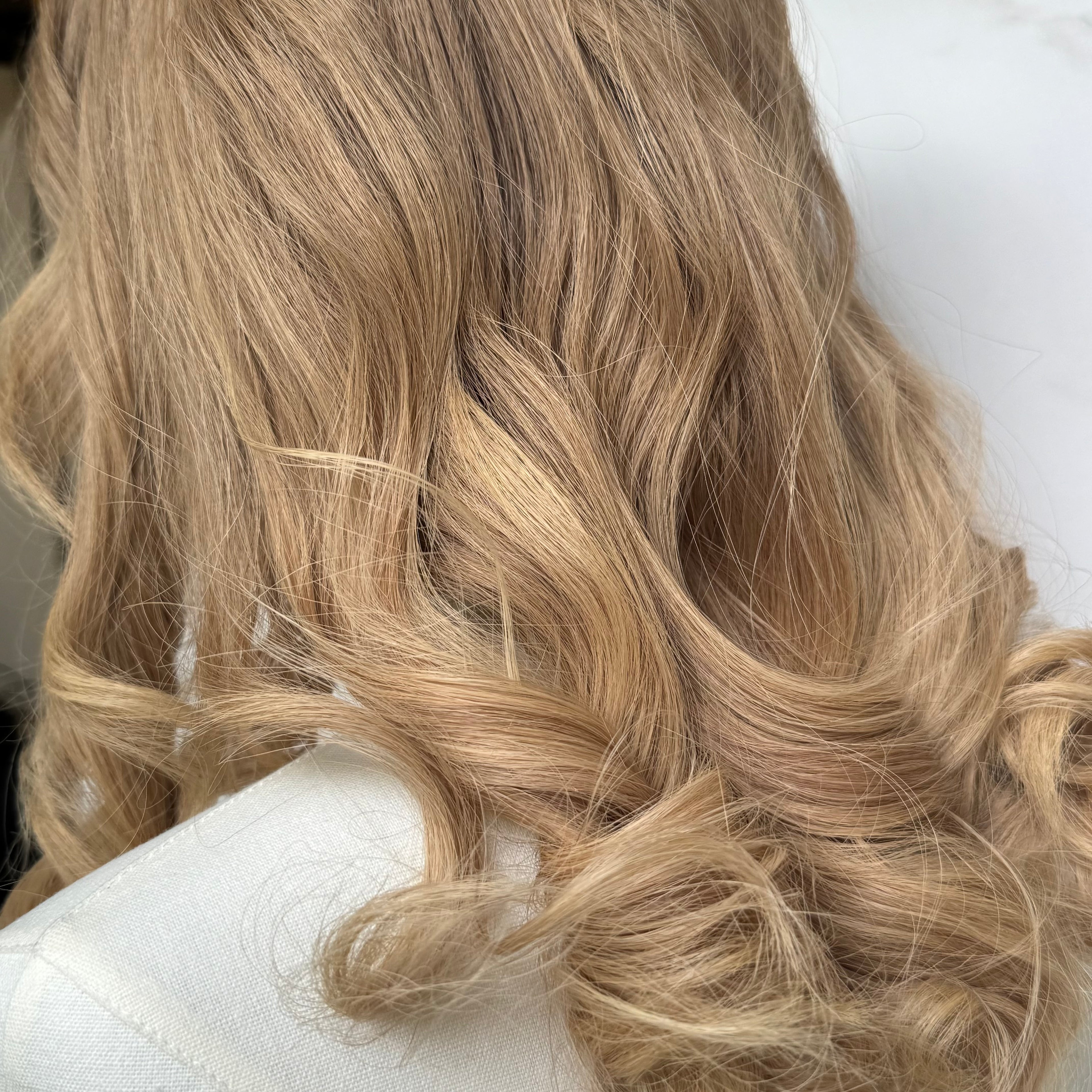 Close-up of blonde wavy hair on a white background