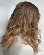 Blonde wig with wavy hair on a white background