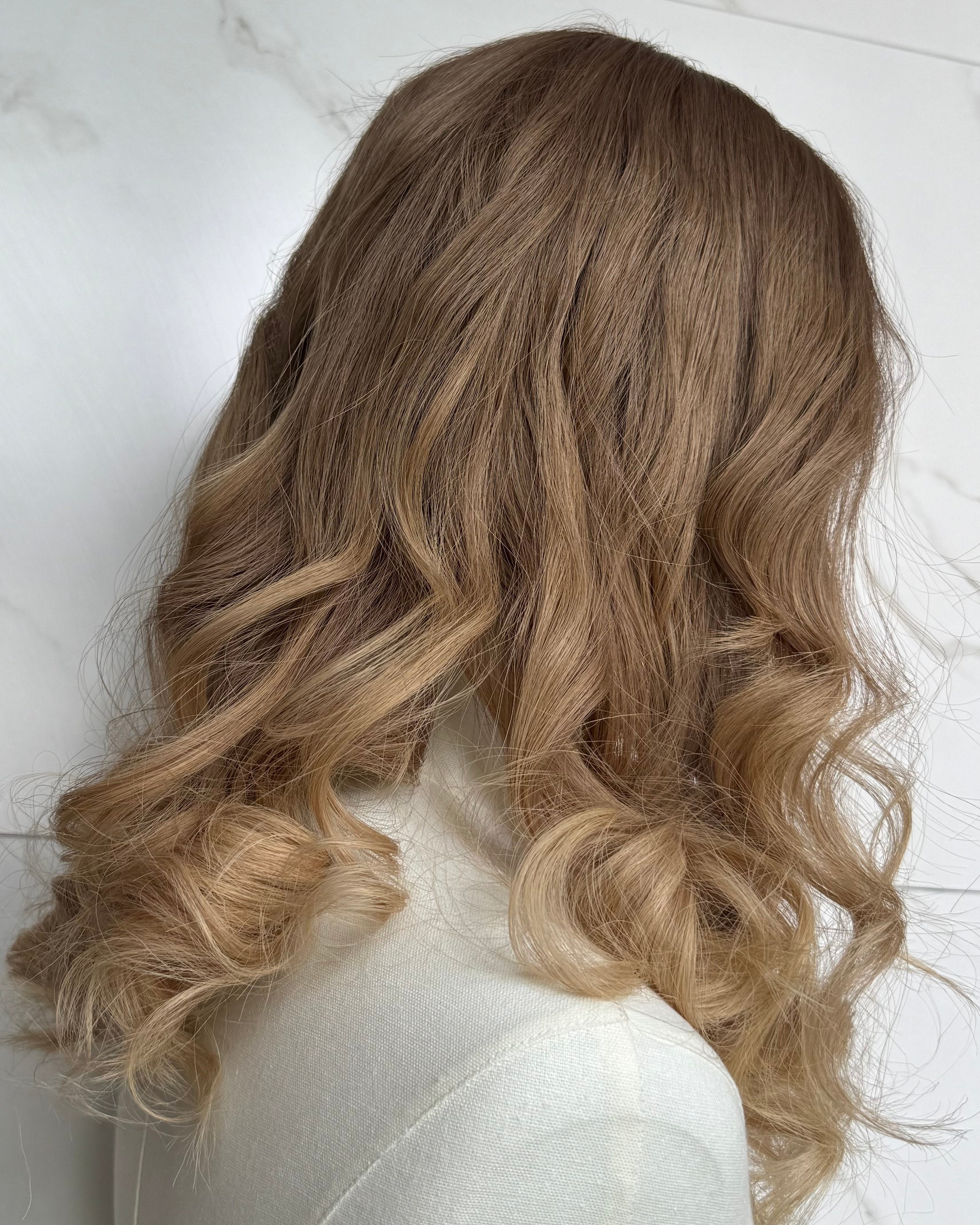 Blonde wig with wavy hair on a white background