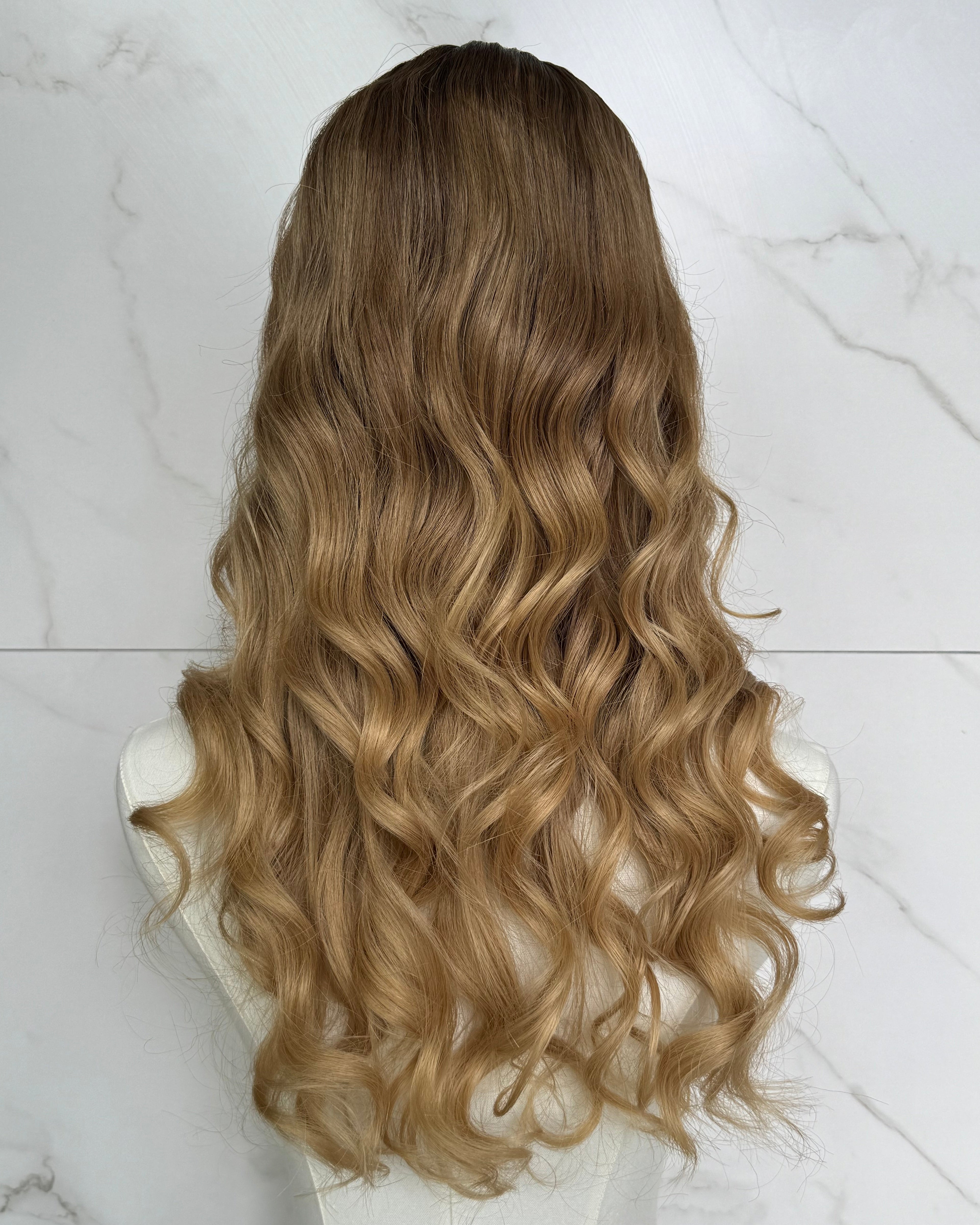 Blonde hair wig on a white marble surface