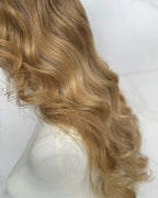 Blonde wig on a mannequin head against a white background