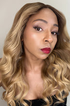 Woman with styled hair and red lipstick against a neutral background