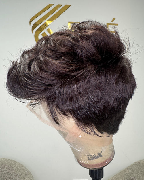 Side view of Ora virgin full lace pixie wig on a mannequin showing the warm light brown colour, natural texture, and full lace cap construction against a Keré Hair branded background
