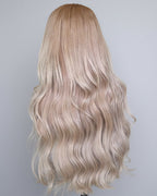 Blonde wig with wavy Vietnamese raw hair on a mannequin head against a plain background.